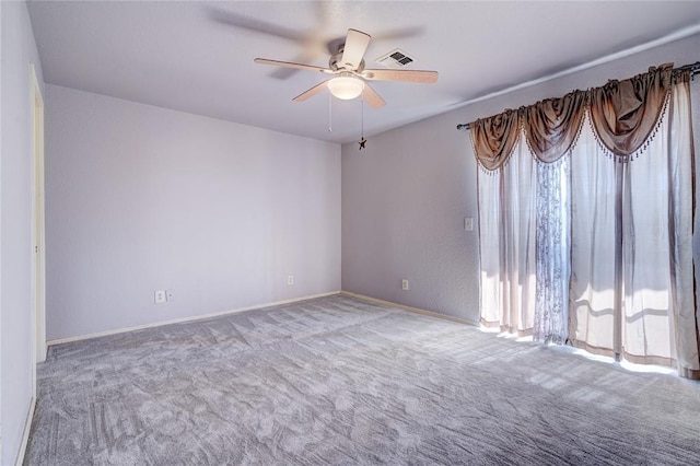 carpeted spare room featuring ceiling fan