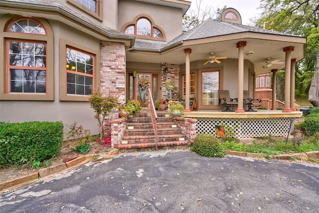 view of exterior entry featuring ceiling fan and a porch