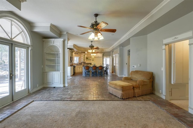 unfurnished living room featuring french doors, ceiling fan, crown molding, and carpet