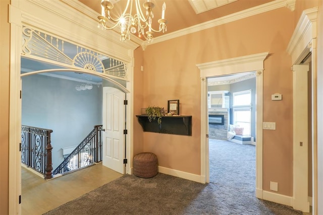 corridor with an inviting chandelier, ornamental molding, and carpet floors