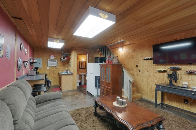 living room with an AC wall unit, sink, wood ceiling, and wooden walls