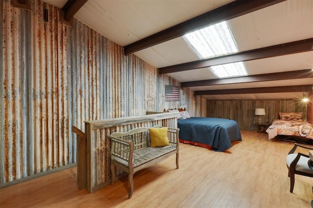 bedroom with vaulted ceiling with beams and light wood-type flooring