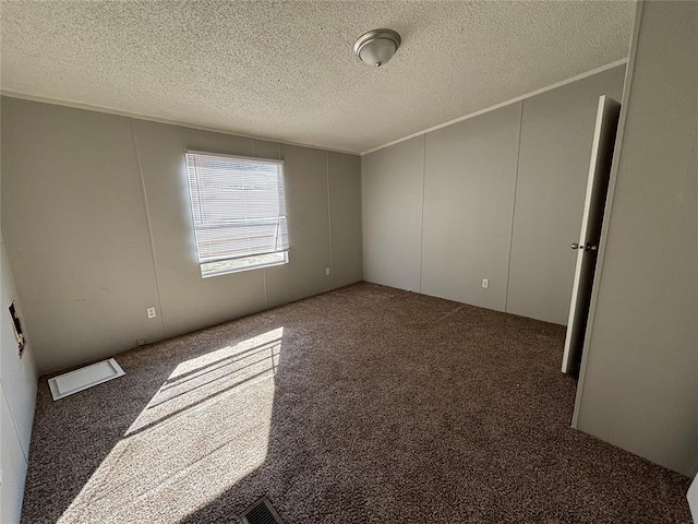 carpeted spare room with a textured ceiling