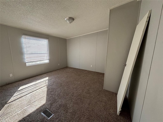 carpeted spare room with a textured ceiling