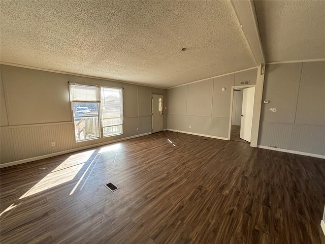 unfurnished living room featuring lofted ceiling, crown molding, dark hardwood / wood-style floors, and a textured ceiling