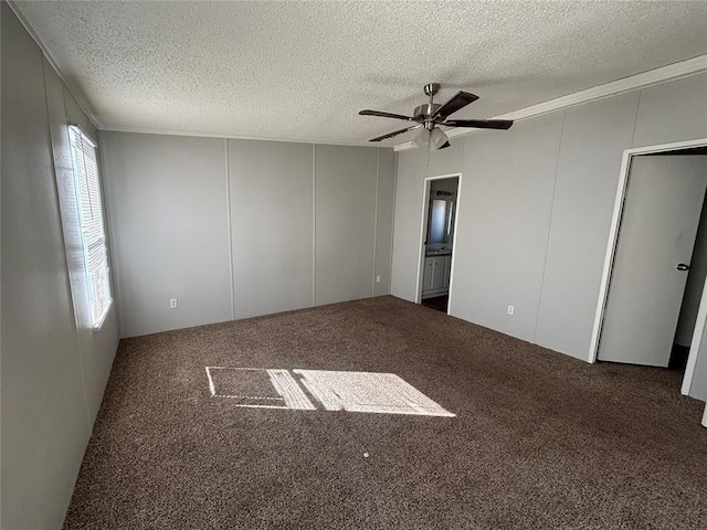 carpeted spare room featuring ceiling fan and a textured ceiling