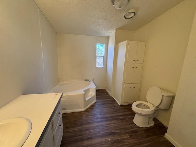 bathroom with a tub to relax in, toilet, wood-type flooring, a textured ceiling, and vanity