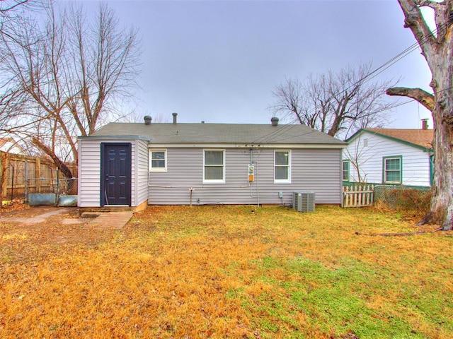 back of property with a yard and central air condition unit