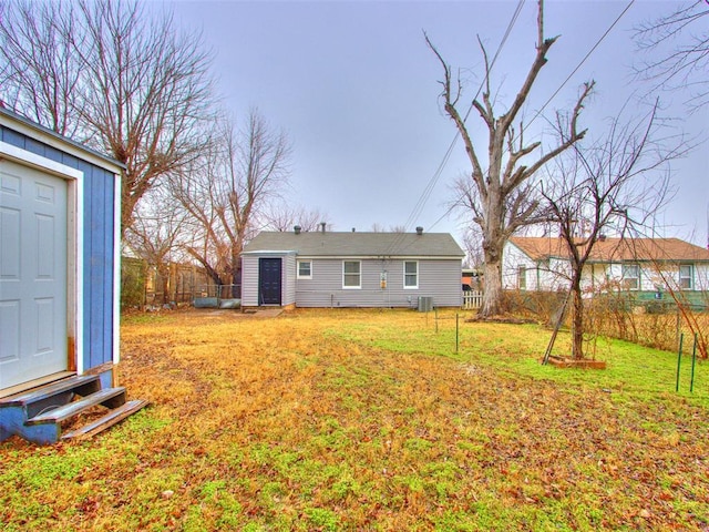 rear view of property featuring an outbuilding and a lawn