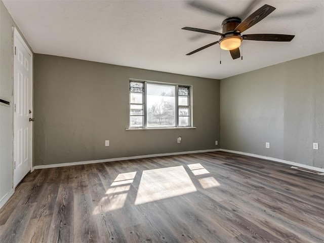 unfurnished room featuring dark wood-type flooring and ceiling fan