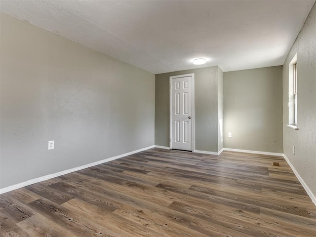 unfurnished room featuring dark wood-type flooring