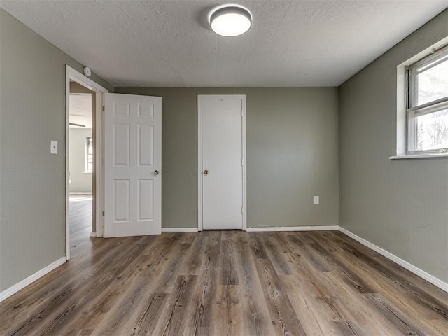 unfurnished bedroom featuring dark hardwood / wood-style floors and a textured ceiling