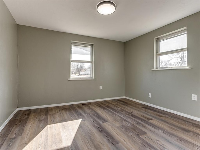 unfurnished room with dark hardwood / wood-style flooring and plenty of natural light