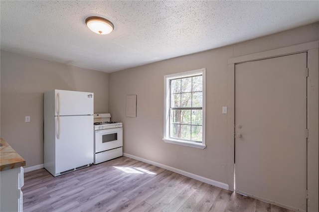 kitchen with white appliances, light hardwood / wood-style flooring, and a textured ceiling