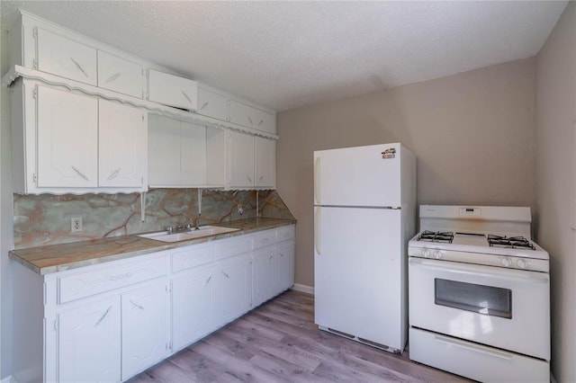 kitchen featuring sink, white appliances, light hardwood / wood-style flooring, backsplash, and white cabinets