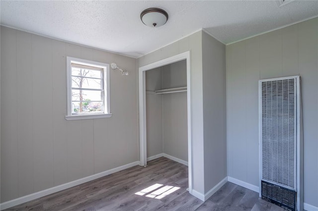 unfurnished bedroom with hardwood / wood-style flooring, a closet, and a textured ceiling