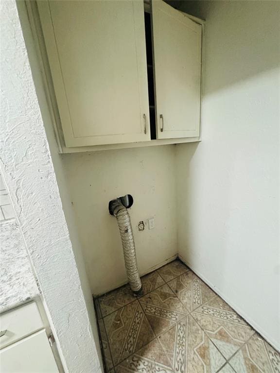 laundry room with light tile patterned flooring and cabinet space