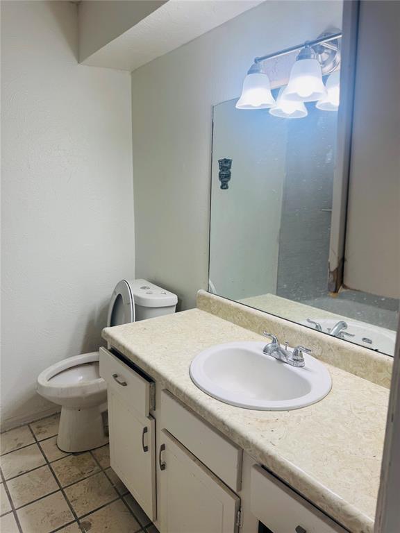 bathroom featuring tile patterned flooring, vanity, and toilet