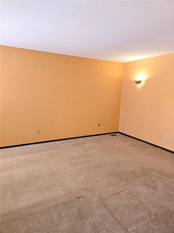 carpeted empty room featuring a textured ceiling