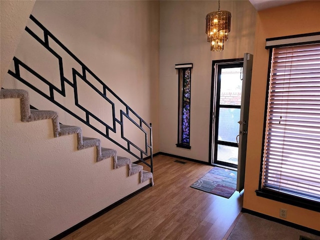 entrance foyer with hardwood / wood-style floors and a notable chandelier