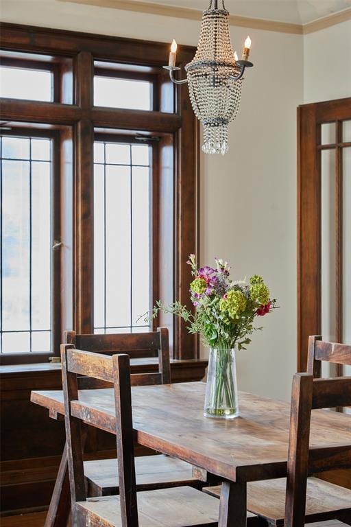 dining space featuring crown molding and a notable chandelier