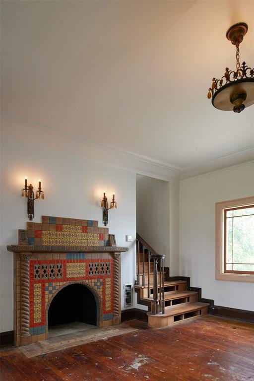 stairway with crown molding, a fireplace, and hardwood / wood-style floors