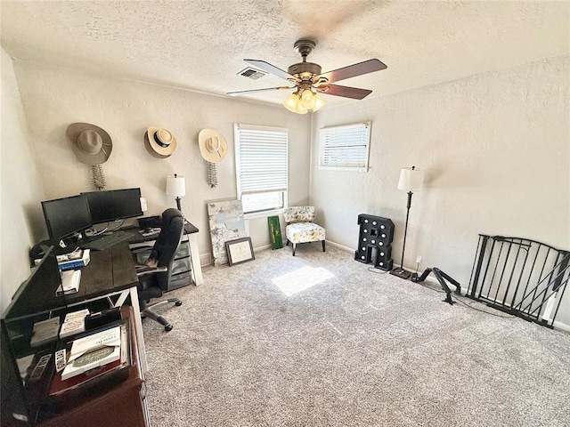 home office featuring ceiling fan, carpet flooring, and a textured ceiling