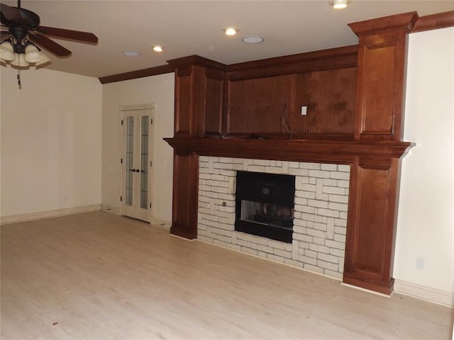 unfurnished living room with ceiling fan, light wood-type flooring, and a fireplace