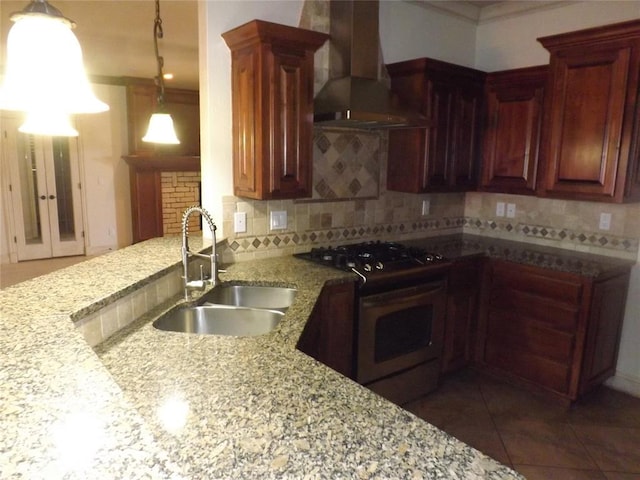 kitchen featuring stainless steel gas range, extractor fan, sink, pendant lighting, and backsplash