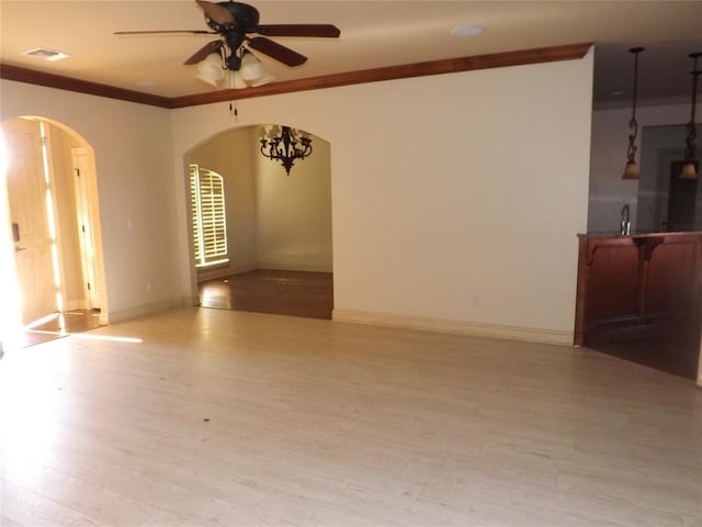 spare room featuring crown molding, ceiling fan, and light hardwood / wood-style flooring