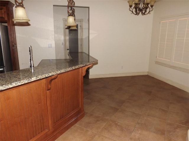 kitchen featuring hanging light fixtures, dark stone countertops, and an inviting chandelier