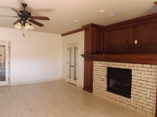 unfurnished living room featuring ceiling fan, a fireplace, and light hardwood / wood-style floors