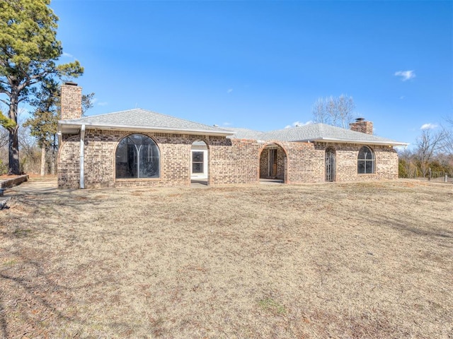 rear view of house featuring a lawn