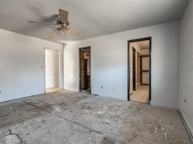 unfurnished bedroom with connected bathroom, a spacious closet, a closet, and ceiling fan