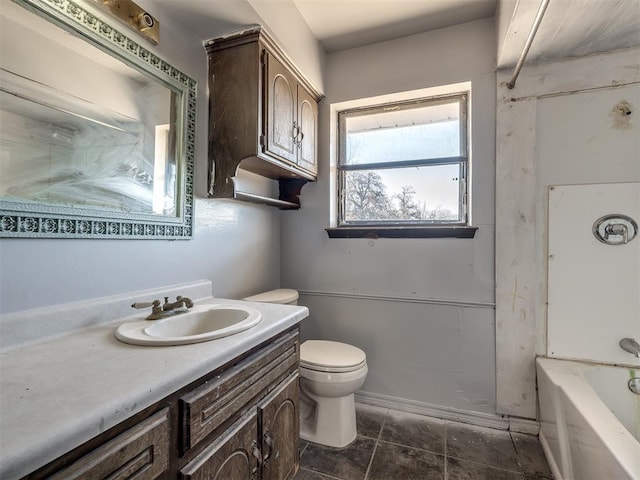 bathroom with vanity, a tub, and toilet