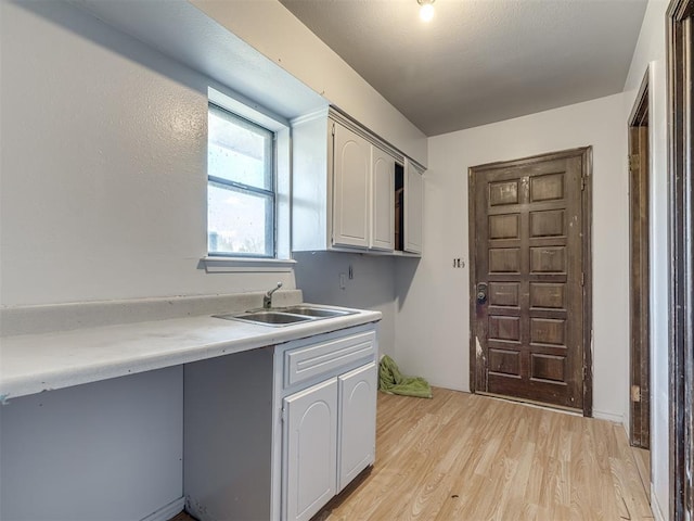 kitchen featuring sink, gray cabinetry, and light hardwood / wood-style flooring