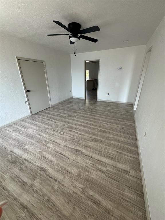 spare room with ceiling fan, hardwood / wood-style floors, and a textured ceiling