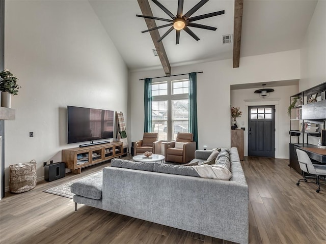 living room with a healthy amount of sunlight, wood-type flooring, high vaulted ceiling, and beamed ceiling