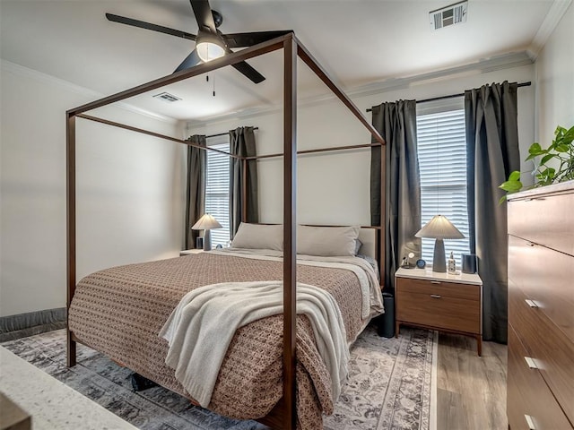 bedroom featuring hardwood / wood-style flooring, crown molding, and ceiling fan