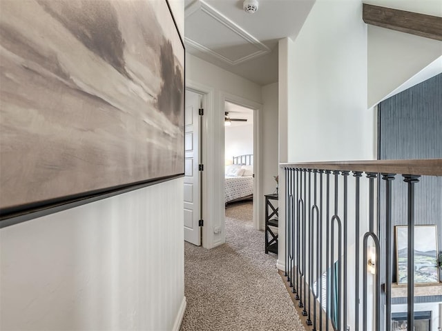 hallway with carpet floors and beamed ceiling