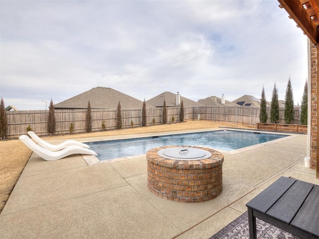 view of pool featuring a water slide, a patio area, and a fire pit