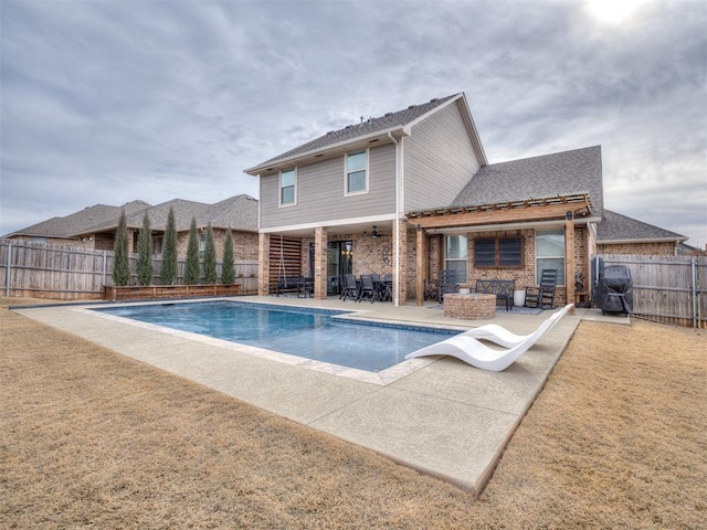 view of swimming pool featuring an outdoor fire pit, a water slide, a patio, and a lawn