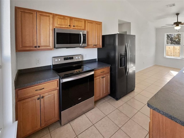 kitchen featuring light tile patterned flooring, ceiling fan, and stainless steel appliances