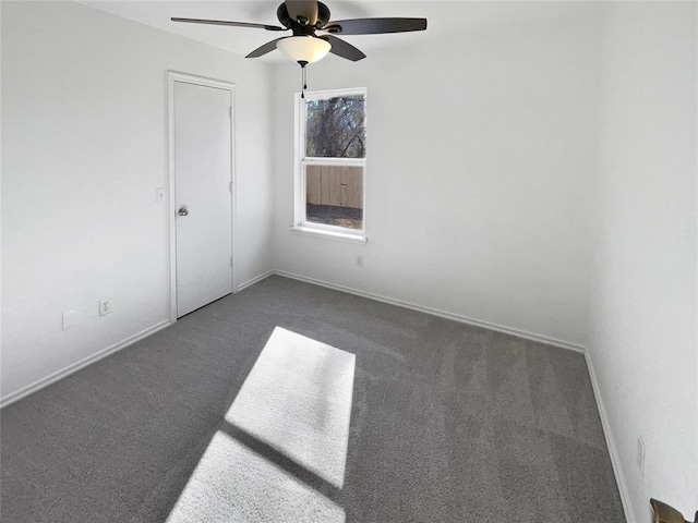 empty room featuring dark carpet and ceiling fan