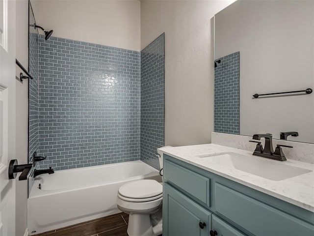 full bathroom with tiled shower / bath combo, wood-type flooring, vanity, and toilet