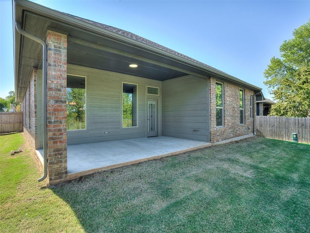 back of property featuring a lawn and a patio area