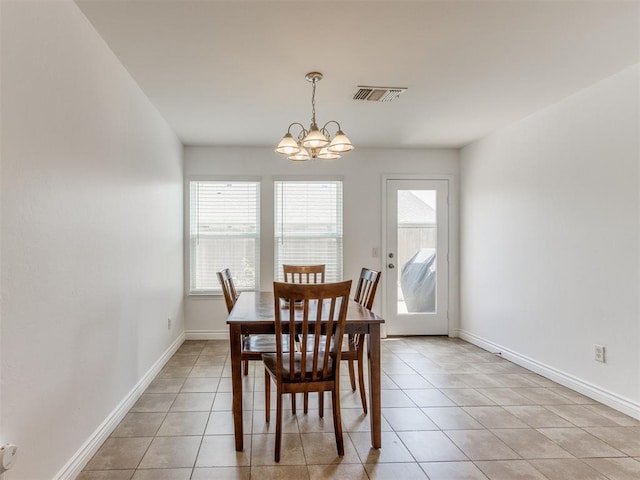 dining area with light tile patterned floors and a notable chandelier