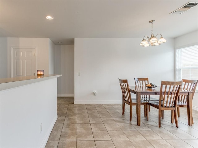 tiled dining room with a chandelier