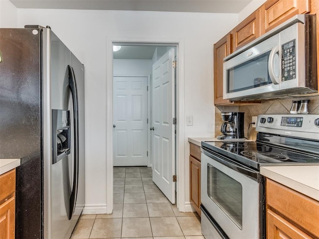 kitchen featuring light tile patterned flooring and appliances with stainless steel finishes