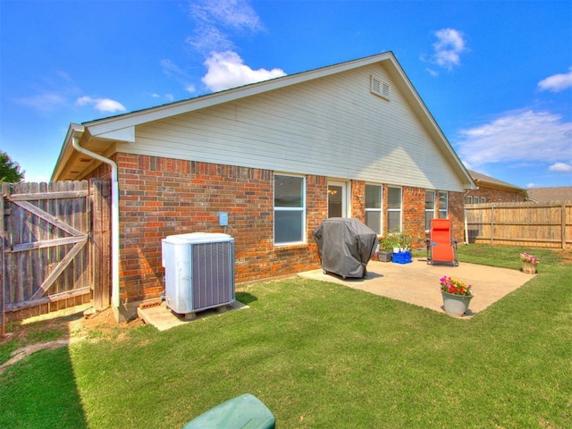 back of property featuring cooling unit, a patio, and a lawn